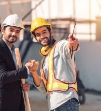 Happy workers at construction site, young civil engineer manager and architects handshaking at construction site and looking to next construction phase  , cooperation teamwork concept.